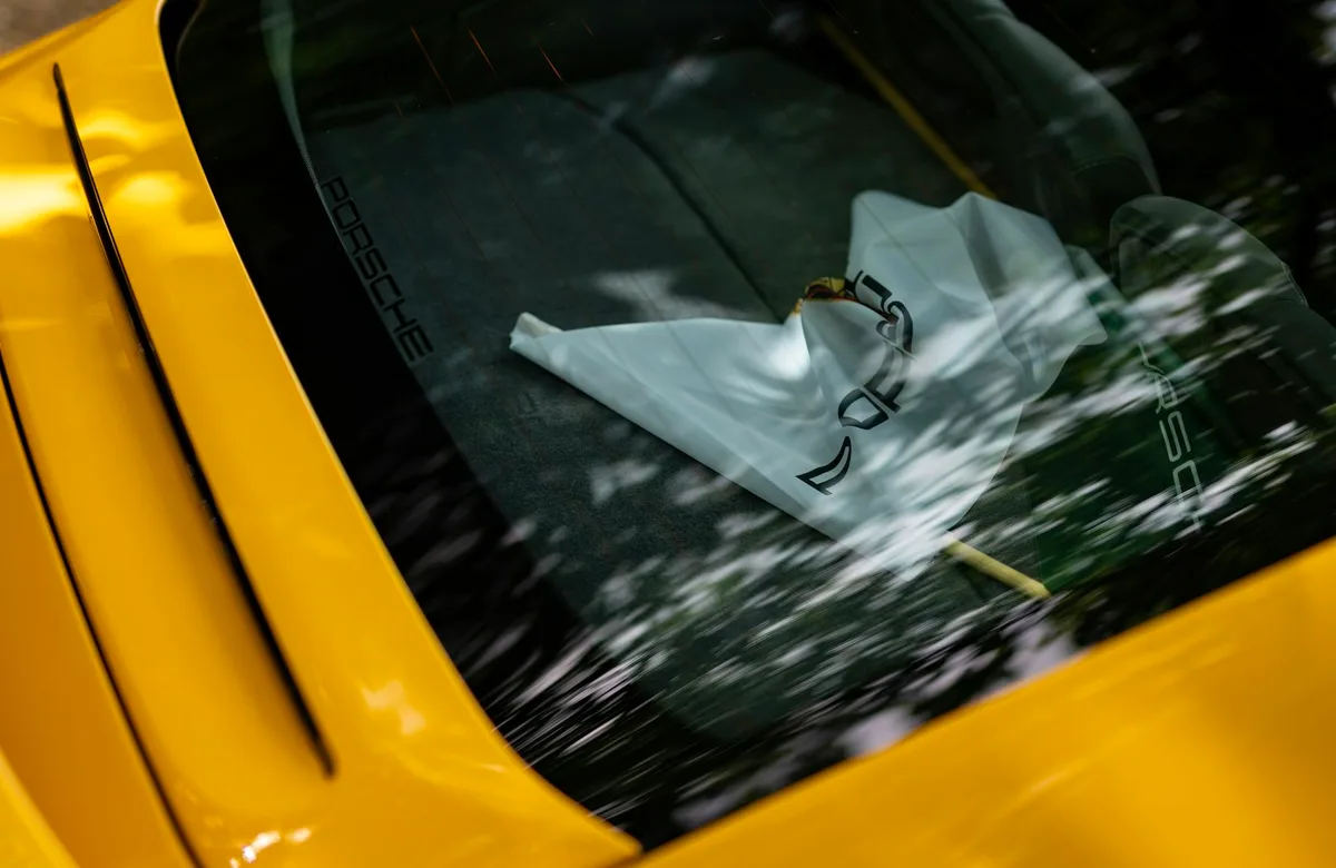 Window and interior detail of a yellow Porsche; illustrative model inspiration, not a vehicle for sale